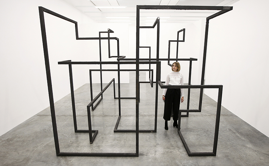A member of the gallery staff poses for a photograph with a piece called "Run", by artist Antony Gormley, which forms part of an exhibition entitled "Fit", at the White Cube gallery in London, Britain September 29, 2016.   REUTERS/Peter Nicholls